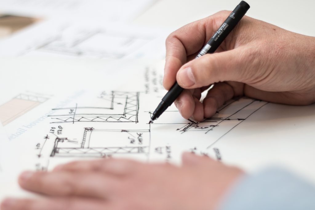 Close-up of architect drawing a floor plan with a black marker on white paper