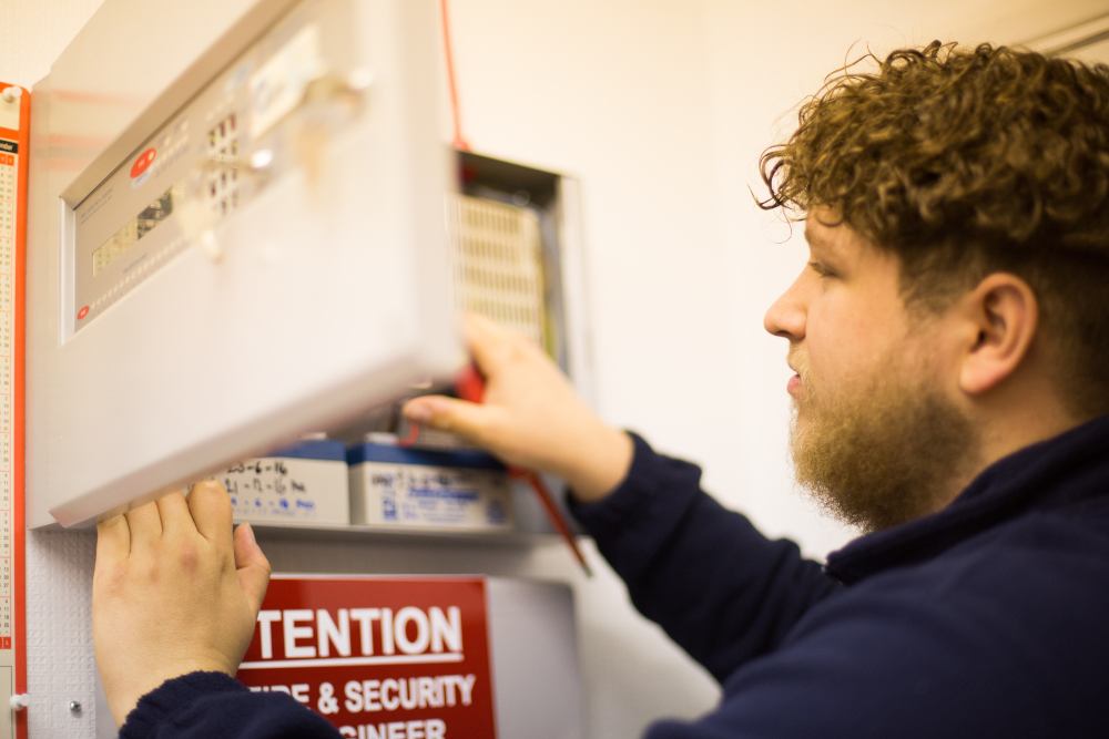Fire alarm engineer working on a fire alarm panel
