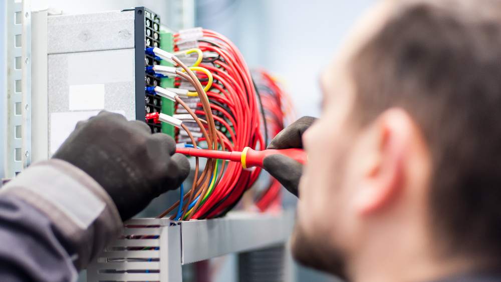 Close up of an electrician and wires with gloves on