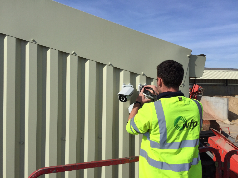 WFP Engineer in high vis working on a camera